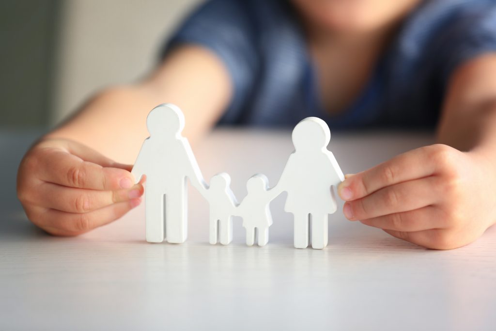 Child holding paper cut out mold of family